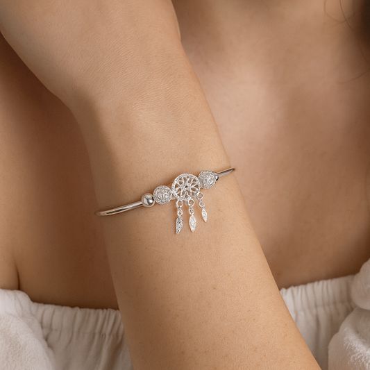 Silver bracelet with a dreamcatcher design on a wrist