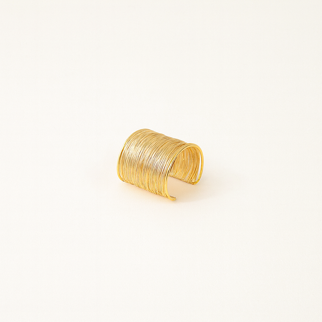Gold cuff bracelet with textured, layered design on a plain white background. Elegant jewelry accessory, perfect for fashion and style enthusiasts.