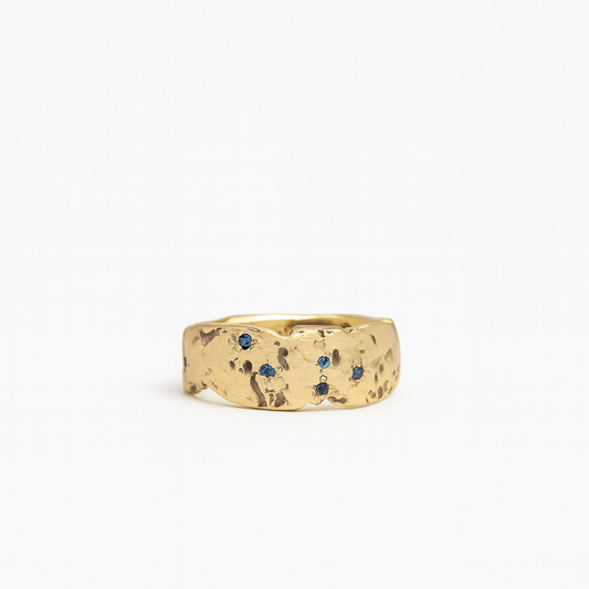 Gold ring with blue gemstones on a white background