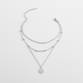 Triple-layered silver necklace with a coin pendant, featuring a sleek chain, beaded accents, and adjustable clasp. Elegant jewelry for women.
