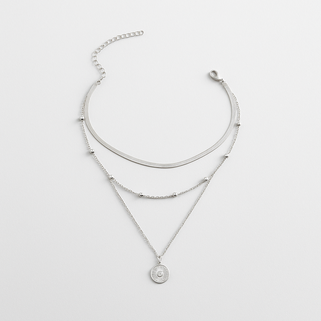 Triple-layered silver necklace with a coin pendant, featuring a sleek chain, beaded accents, and adjustable clasp. Elegant jewelry for women.