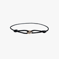 Black cord bracelet with a gold clasp on a white background