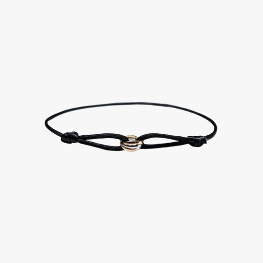 Black cord bracelet with a gold clasp on a white background