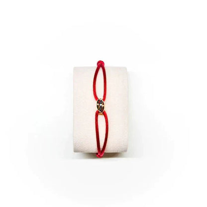 Red bracelet on a white cylindrical object with a white background
