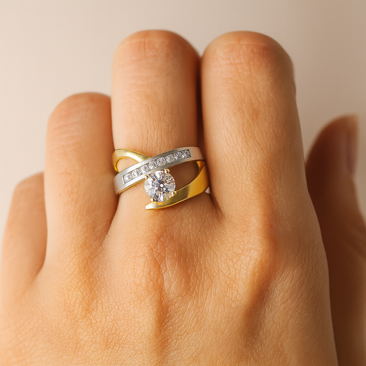 Gold and silver ring with a diamond on a hand against a beige background