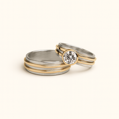 Two gold and silver rings with a diamond on a beige background