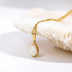 Gold chain necklace with teardrop opal pendant on white coral background, elegant jewelry, opal necklace, luxury accessory, minimalist design.