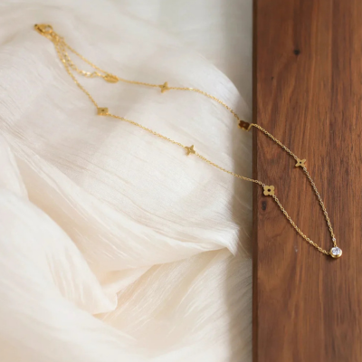 Gold-Tone Necklace with Polished Floral Motifs and Center Crystal Accent