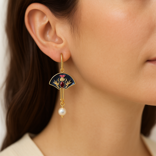 Close-up of a woman wearing an ornate earring with a pearl drop.