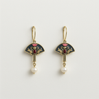 Pair of gold earrings with black fans, red centers, and pearl drops on a light gray background