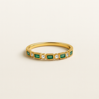 Gold ring with emeralds and diamonds on a beige background