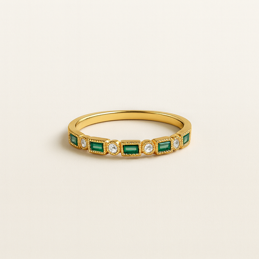 Gold ring with emeralds and diamonds on a beige background