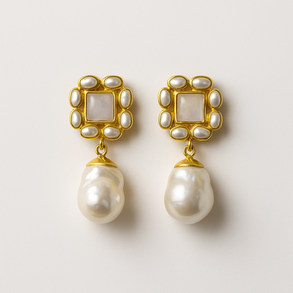 Pair of pearl earrings with gold frames on a light background