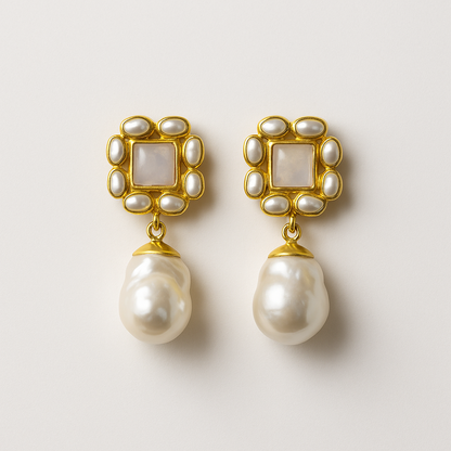 Pair of pearl earrings with gold frames on a light background
