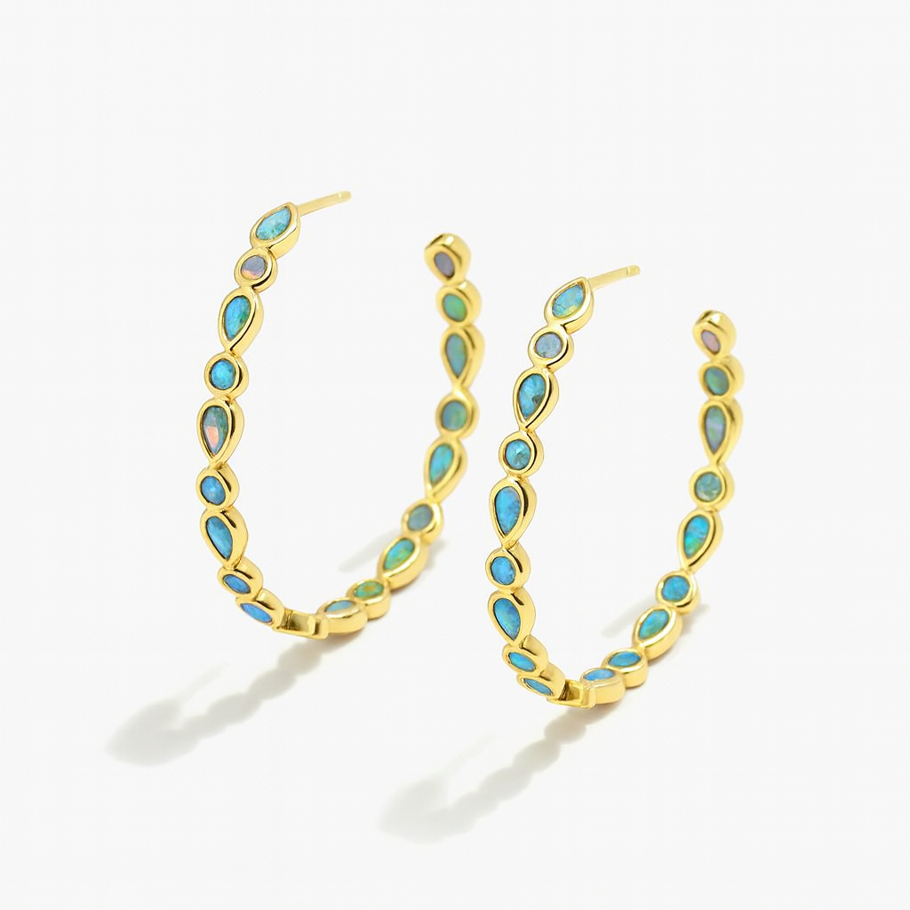 Gold hoop earrings with turquoise stones on a white background
