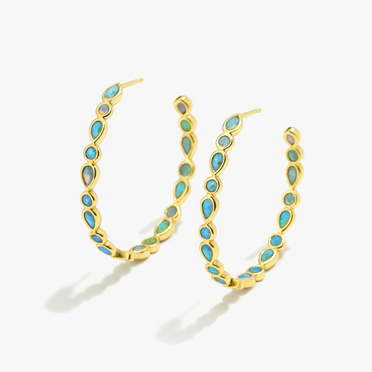 Gold hoop earrings with turquoise stones on a white background