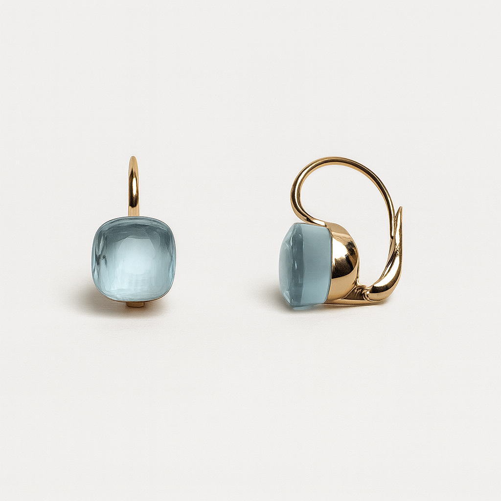 Gold earrings with light blue gemstones on a white background