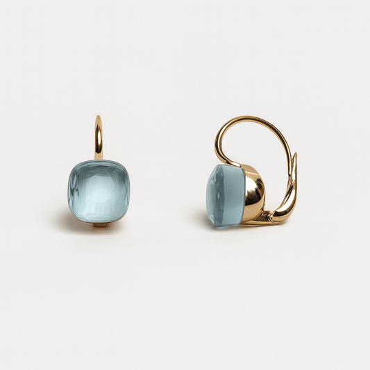 Gold earrings with light blue gemstones on a white background