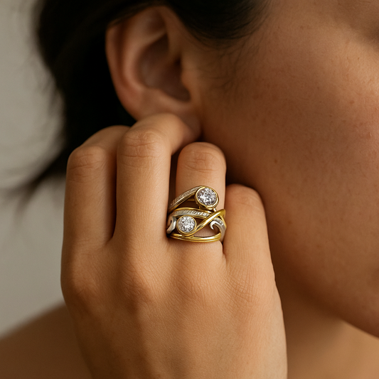 Close-up of a hand wearing a gold ring with gemstones, touching the ear.