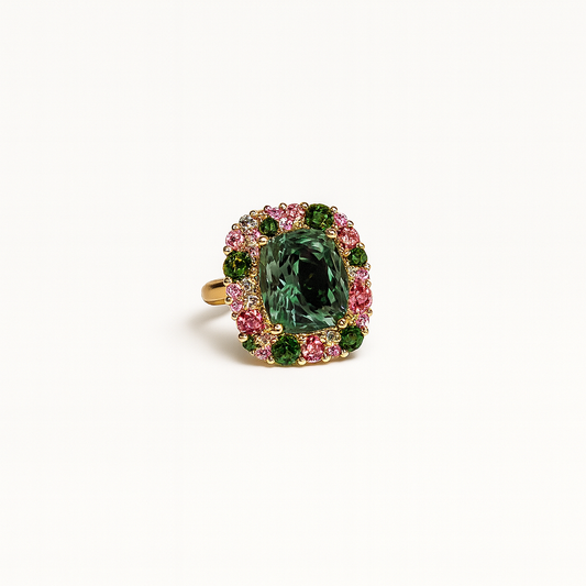 Ring with a green gemstone and pink accents on a white background
