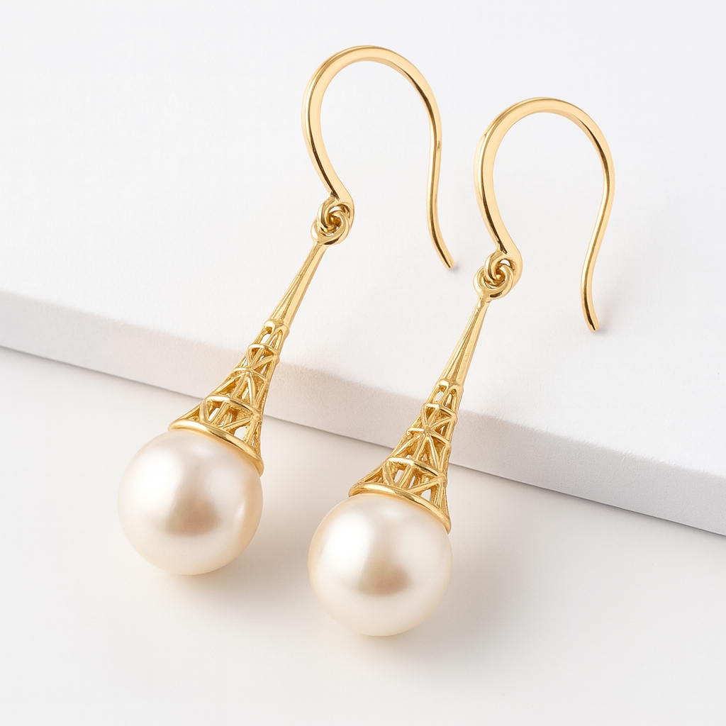 Gold earrings with pearl drops on a white background