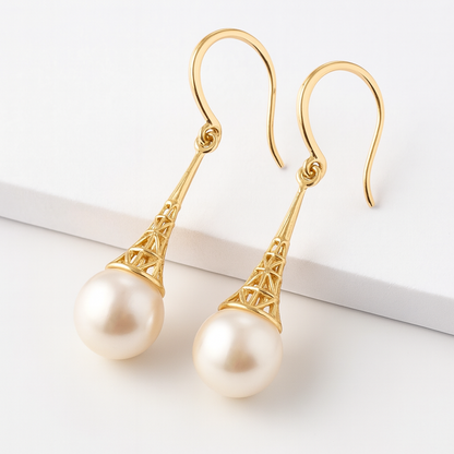 Gold earrings with pearl drops on a white background