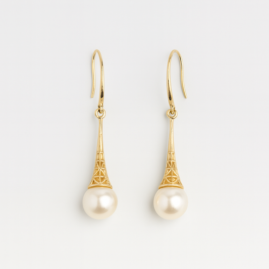 Gold earrings with pearl drops on a light gray background