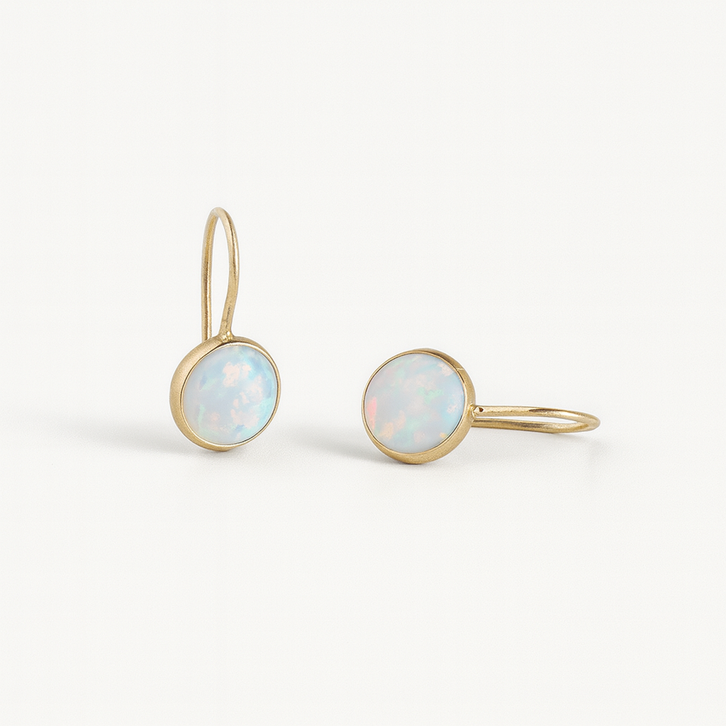Gold earrings with opal stones on a white background