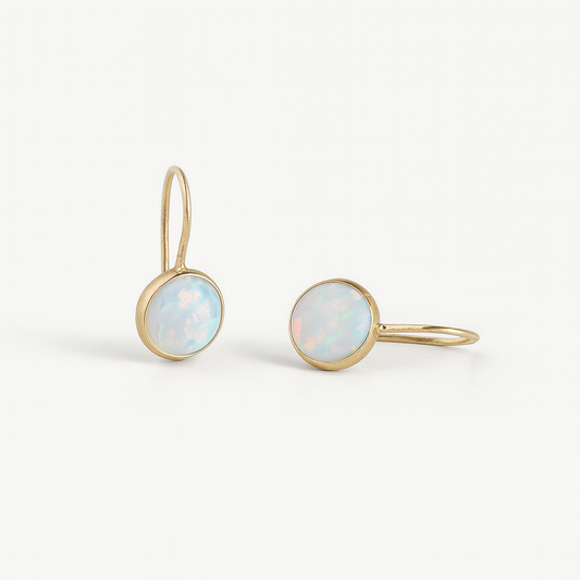 Gold earrings with opal stones on a white background