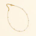 Elegant pearl necklace with gold accents and adjustable chain clasp on a beige background, perfect for fashion and jewelry enthusiasts.