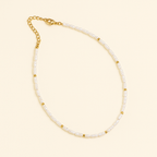 Elegant pearl necklace with gold accents and adjustable chain clasp on a beige background, perfect for fashion and jewelry enthusiasts.