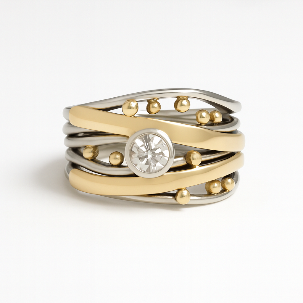 Stack of gold and silver rings with a central gemstone on a white background