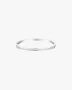 Silver bangle bracelet with a sleek design and subtle diamond accents, perfect for elegant fashion accessories and jewelry collections.