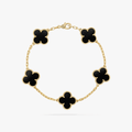 Gold bracelet with five black clover-shaped charms, elegant chain design, luxury jewelry, fashion accessory, Van Cleef & Arpels style.