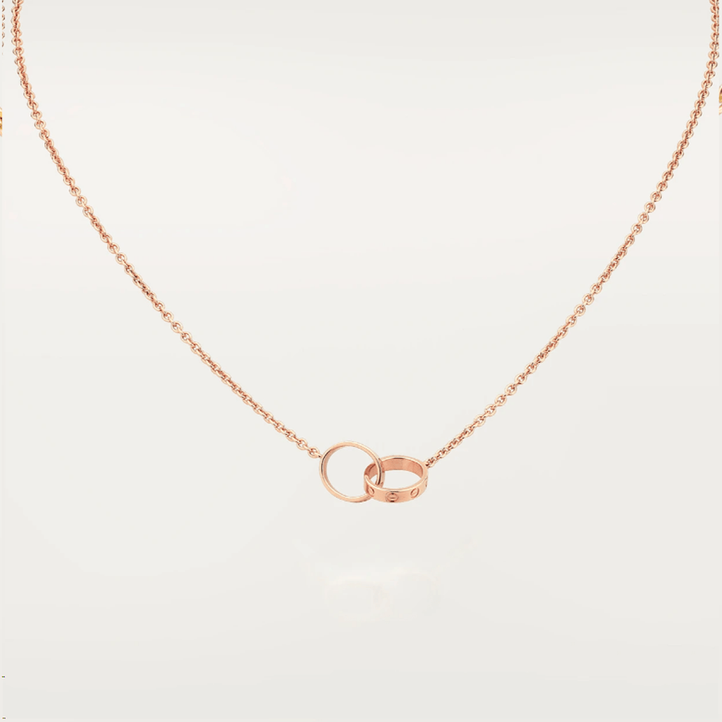 Rose gold necklace with interlocking rings pendant, minimalist jewelry design, elegant chain, perfect for everyday wear or special occasions.