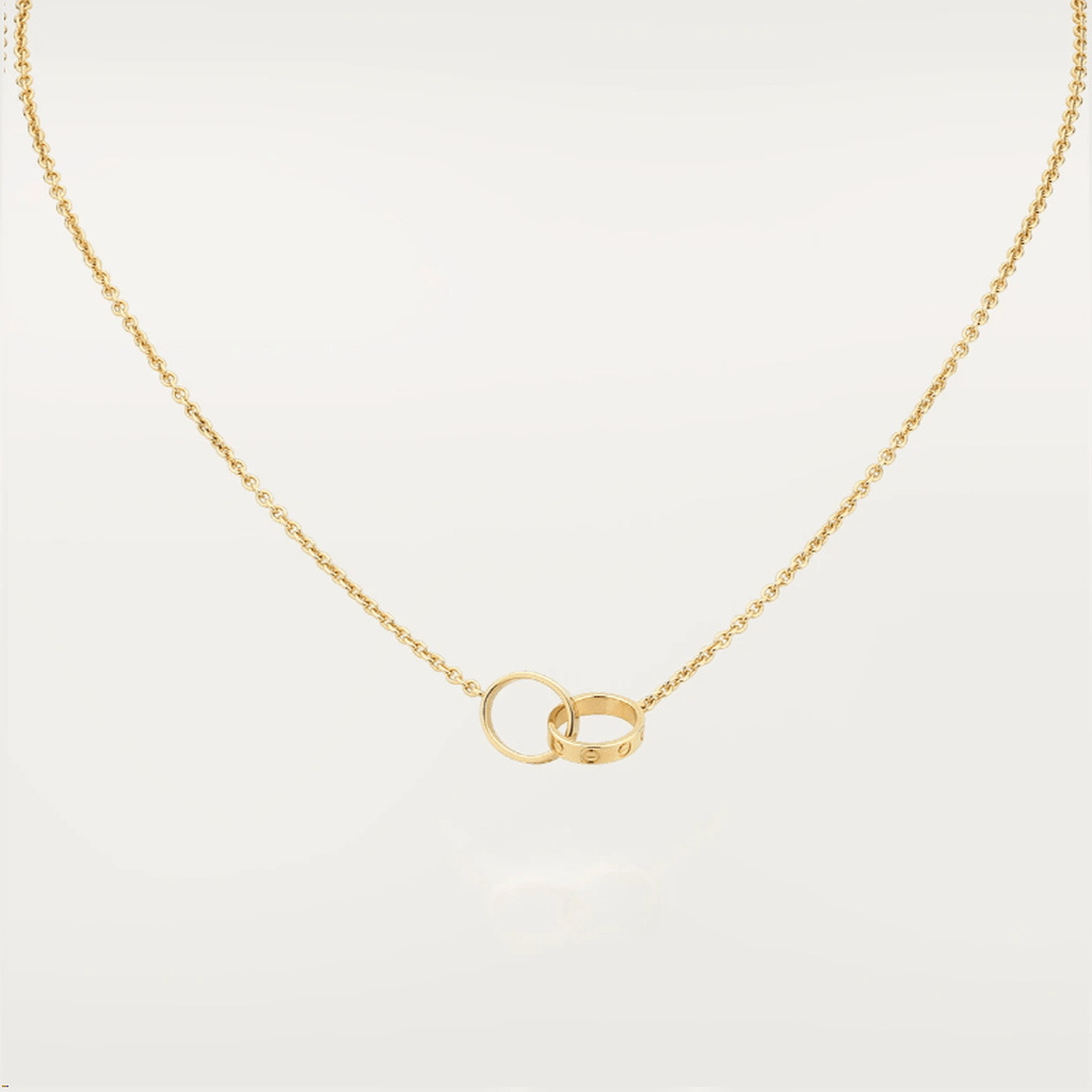 Gold necklace with interlocking rings pendant on a white background. Elegant jewelry piece, perfect for weddings or anniversaries.