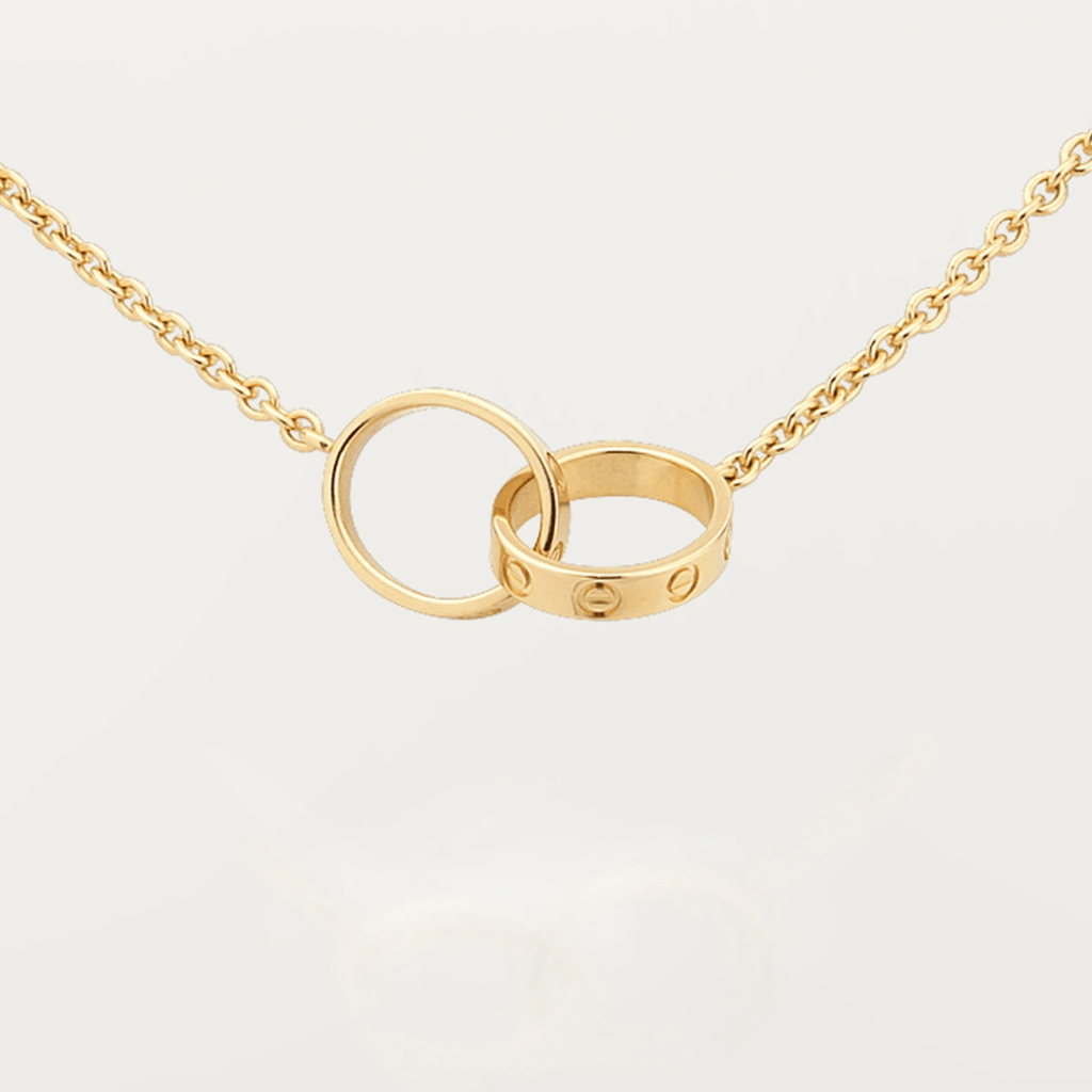 Gold interlocking rings necklace on a delicate chain, featuring a minimalist design. Perfect for elegant jewelry lovers seeking timeless style.