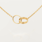 Gold interlocking rings necklace on a delicate chain, featuring a minimalist design. Perfect for elegant jewelry lovers seeking timeless style.