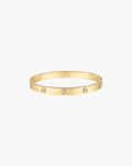 Gold bangle bracelet with embedded round diamonds on a white background. Elegant jewelry accessory, luxury fashion statement piece.