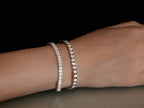 Elegant diamond tennis bracelets on wrist, showcasing luxury jewelry design. Sparkling gemstones, perfect for fashion and style enthusiasts.