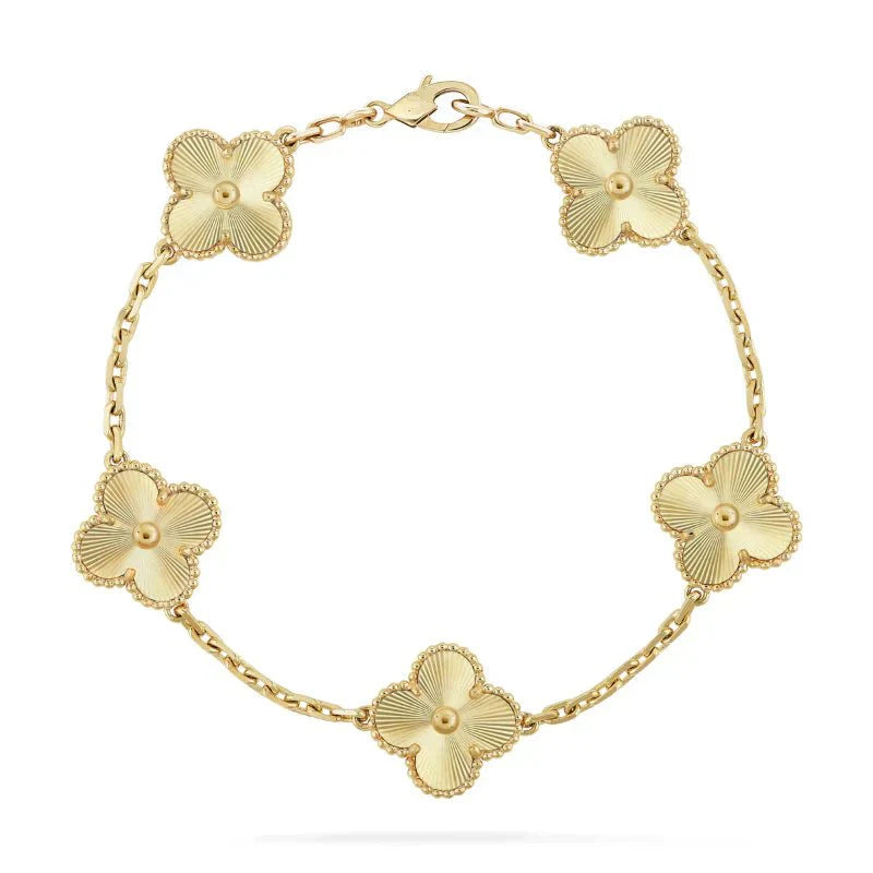 Gold floral bracelet with five clover-shaped charms on a delicate chain, featuring intricate detailing and a secure clasp. Elegant jewelry accessory.