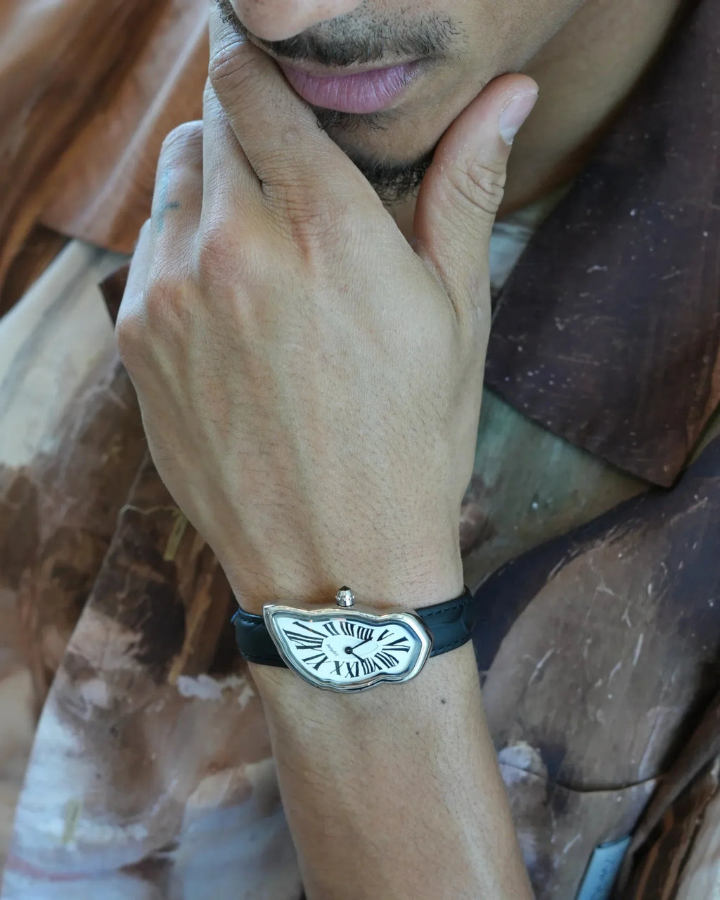 Person wearing a bracelet with a decorative clasp on a blurred background