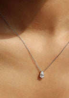 Elegant teardrop diamond necklace on delicate silver chain, showcased on skin. Perfect for luxury jewelry, fashion accessory, and diamond pendant keywords.