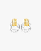 Gold and silver hoop earrings with ribbed design on white background. Fashionable mixed metal jewelry, modern accessory, elegant style.