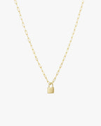 Gold chain necklace with a small padlock pendant, minimalist jewelry design, elegant accessory for women, perfect for layering or standalone wear.