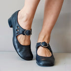 Black shoes with a buckle on a neutral background