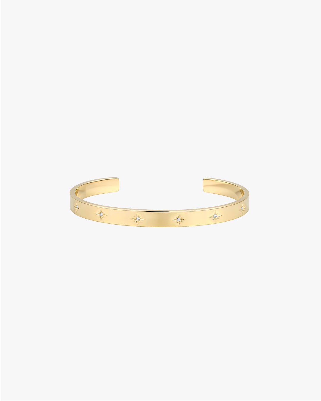 Gold cuff bracelet with star-shaped diamond accents on a white background. Elegant jewelry piece, perfect for fashion accessories and luxury style.