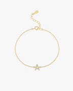 Gold chain bracelet with a diamond-studded letter "A" charm, featuring an adjustable clasp. Elegant jewelry accessory for personalized style.
