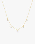 Gold necklace with five dangling diamond pendants on a delicate chain, elegant jewelry, minimalist design, perfect for special occasions.